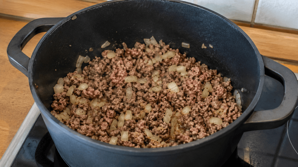 Hackfleisch und Zwiebeln werden für Borsteler Apfelsuppe im Topf angebraten