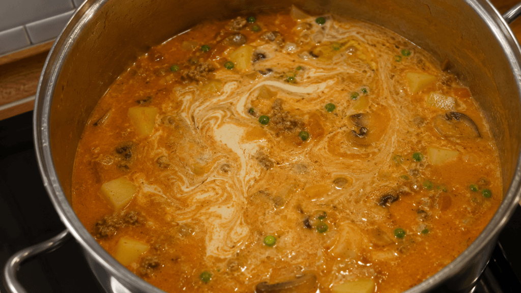 Sahne wird in Borsteler Apfelsuppe eingerührt und macht die Suppe cremig