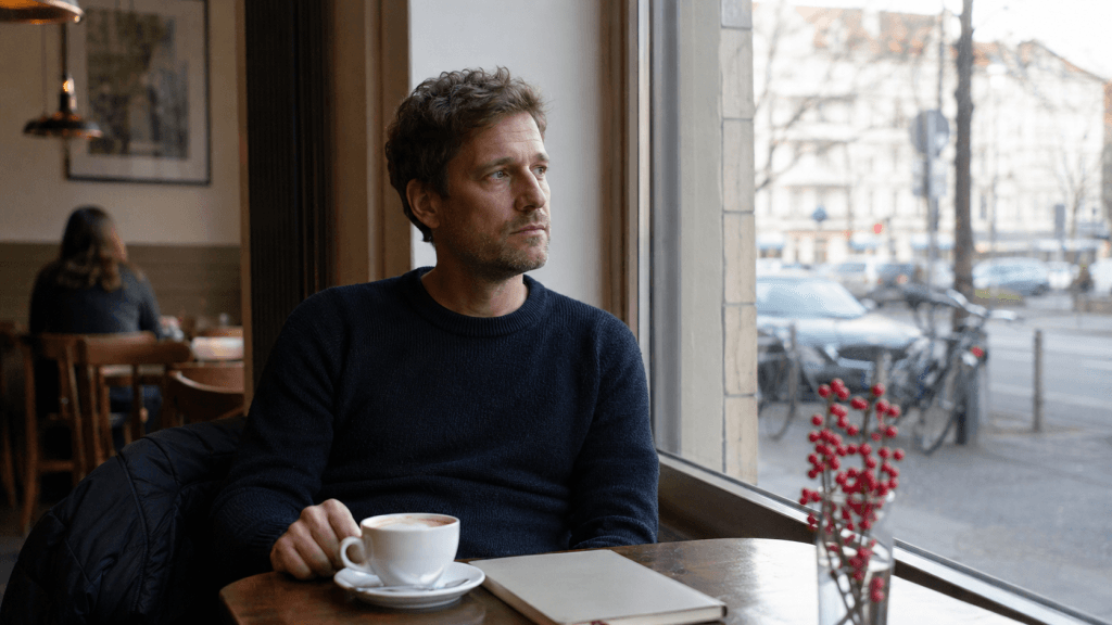 Mann im Café mit Notizbuch bei Gedanken zum Jahreswechsel und stiller Reflexion