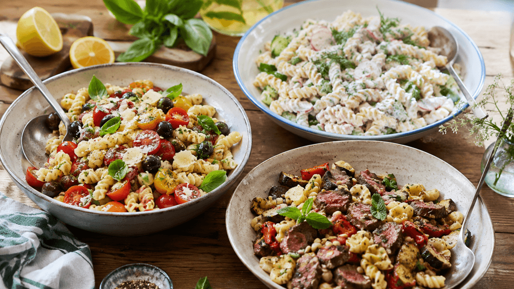 Drei hausgemachte Nudelsalate nach Jamie-Oliver-Art auf einem Sommertisch