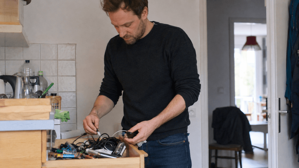 Mann räumt konzentriert eine kleine Küchenschublade auf