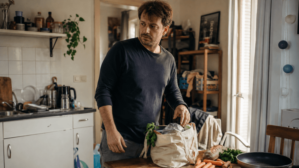 Mann steht am Samstag in der Küche und braucht eine kleine Pause