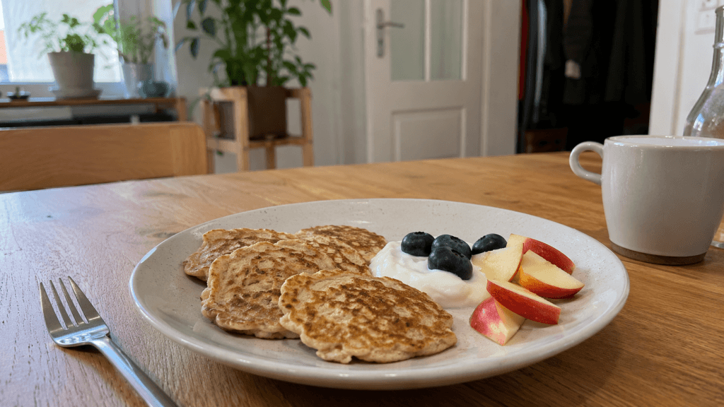 Hausgemachte Bananen-Hafer-Pancakes mit Joghurt, Beeren und Apfel