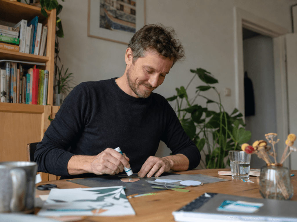 Mann probiert zu Hause ein kreatives Hobby aus und arbeitet mit einfachen Bastelmaterialien