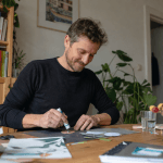 Mann probiert zu Hause ein kreatives Hobby aus und arbeitet mit einfachen Bastelmaterialien