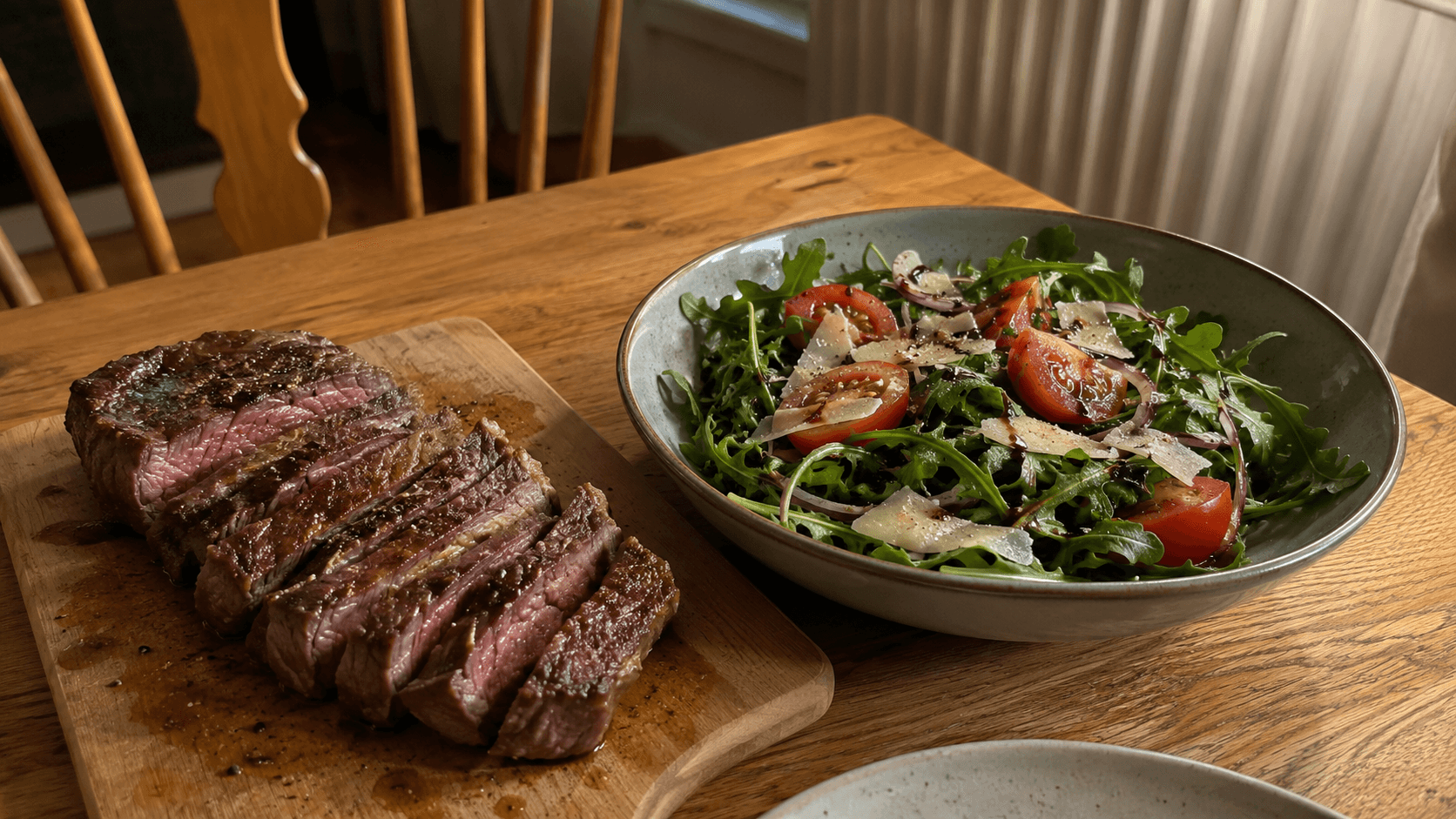 Rucola-Parmesan-Salat in einer Keramikschüssel neben geschnittenem Steak