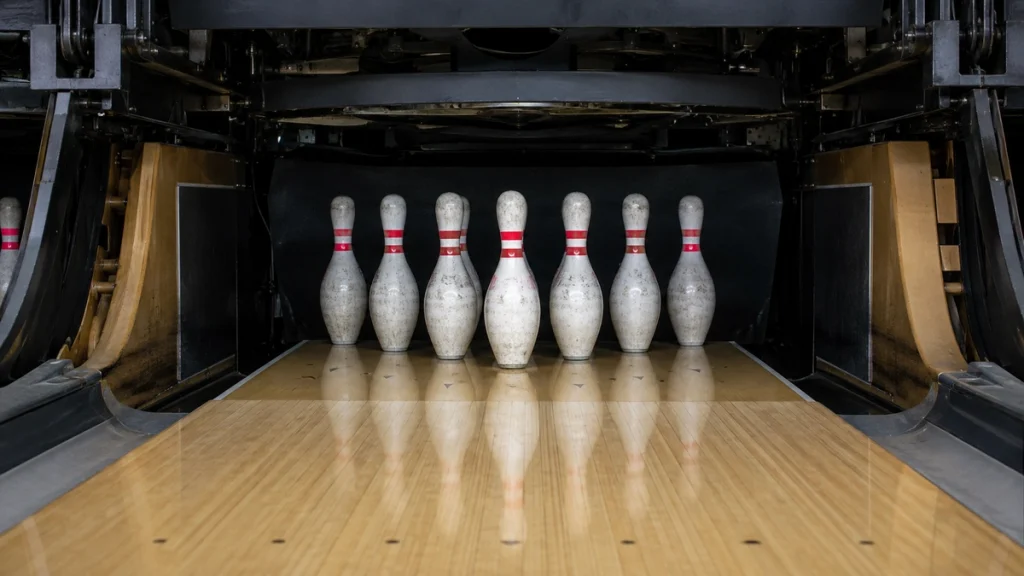Zehn Bowlingpins in korrekter Dreiecksformation vor dem Pinsetter