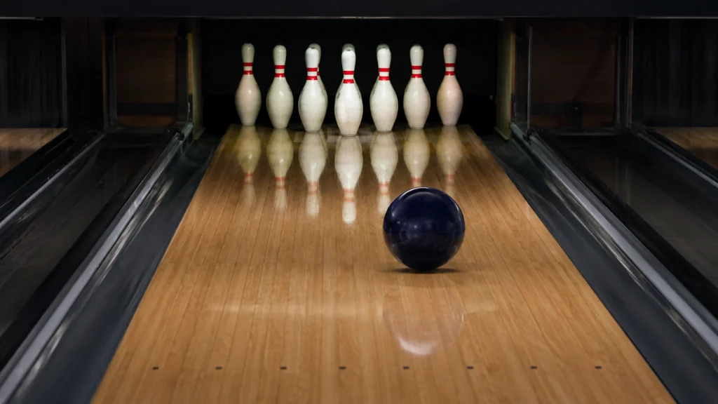 Bowlingwurf für Anfänger: Kugel rollt in Richtung Pocket und Kegel