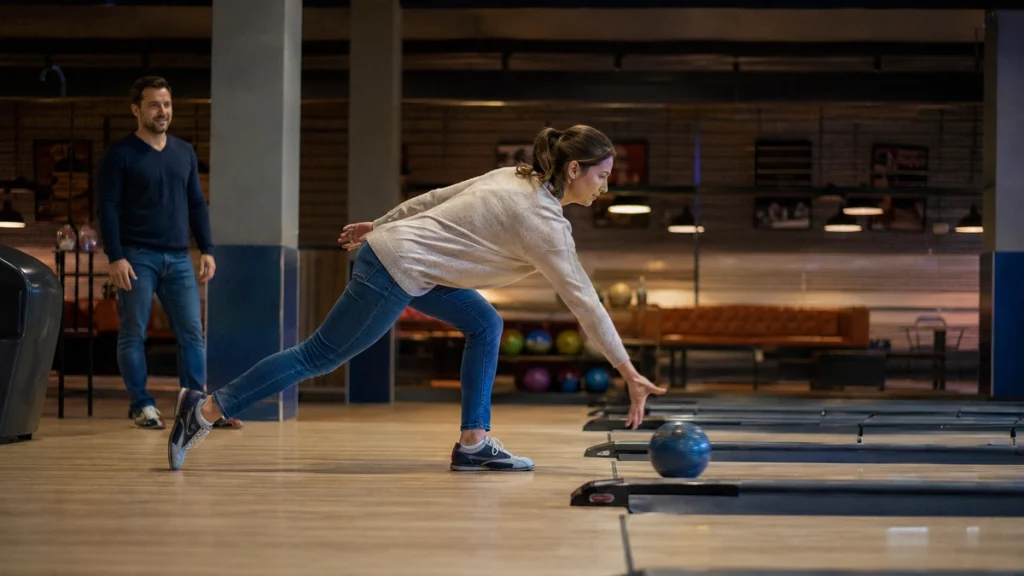 Bowling-Anfängerin lässt die Kugel niedrig über der Bahn los