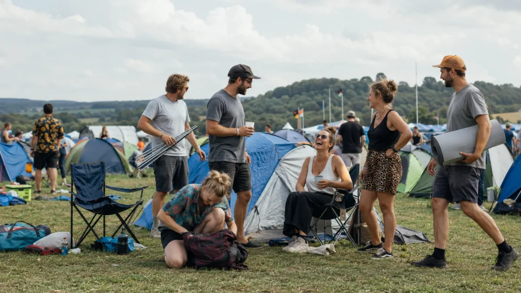 Festival-Packliste für Frauen und Männer beim Camping mit Zelten und Ausrüstung