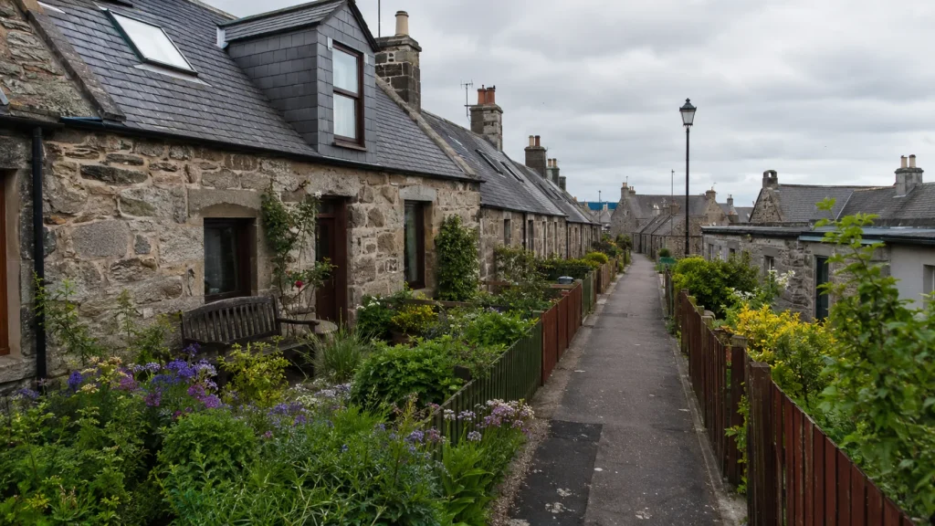 Kleine Gasse mit Steinhaeusern und Gaerten in Footdee Aberdeen