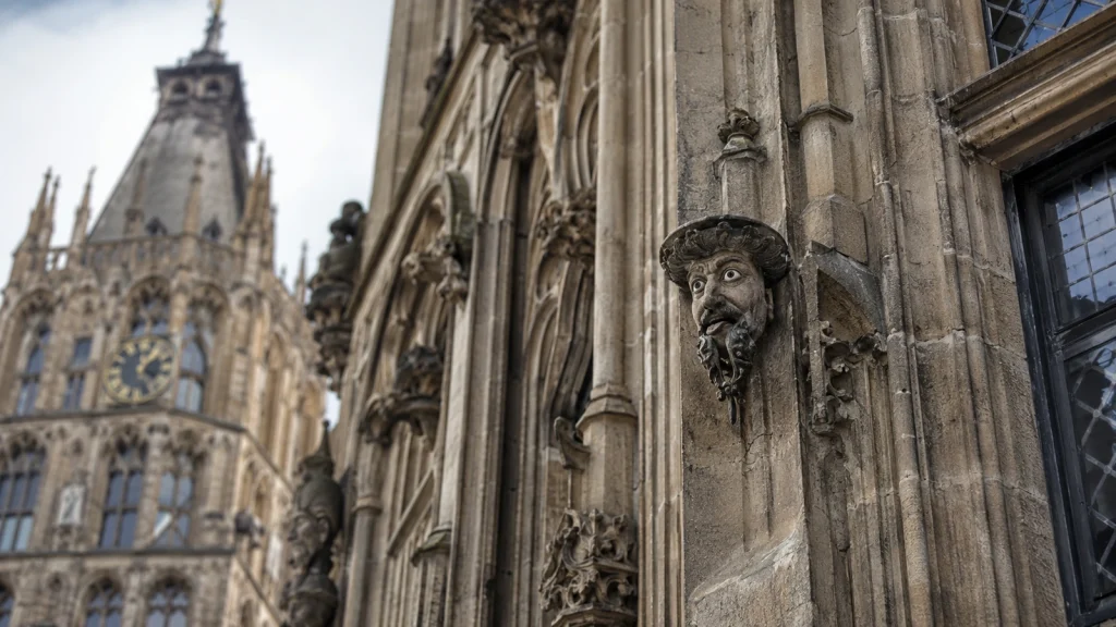 Historische Steinfigur am Kölner Rathaus mit Turm im Hintergrund