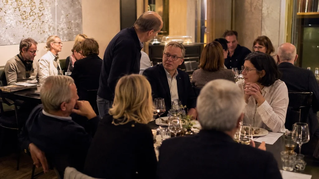 Ehemalige Klassenkameraden unterhalten sich bei einem gemeinsamen Abendessen im Restaurant.