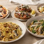 Pasta con le Sarde und Fregola mit Sardinen neben Pizza, Sauerteigbrot und Blumenkohl