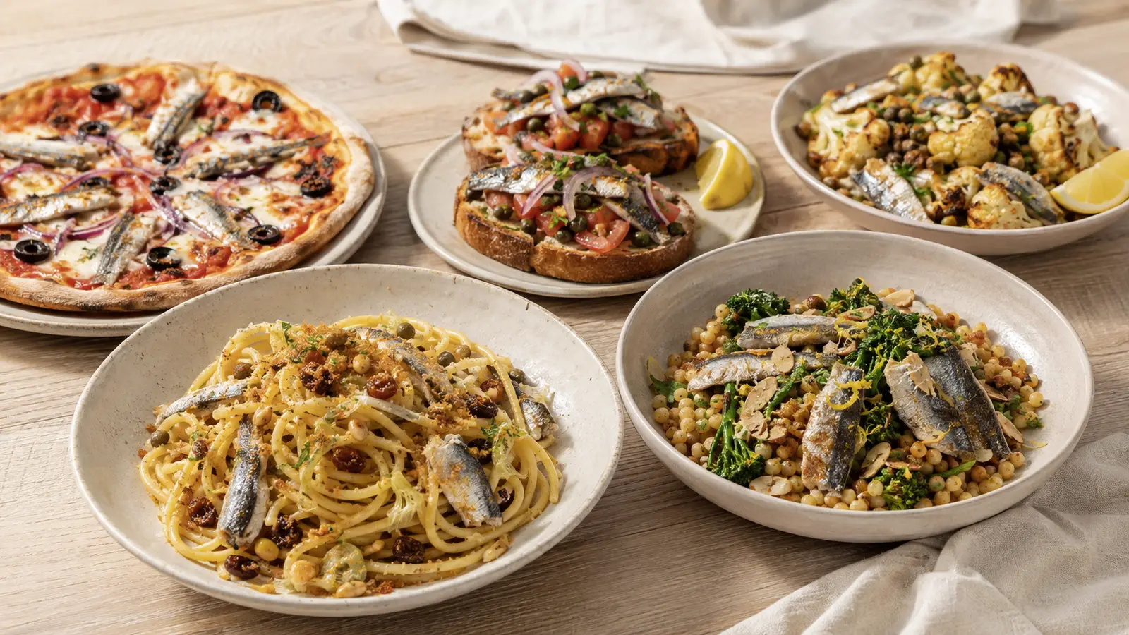 Pasta con le Sarde und Fregola mit Sardinen neben Pizza, Sauerteigbrot und Blumenkohl