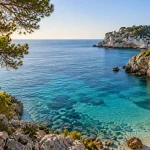 Türkisfarbene Bucht auf Mallorca mit Felsen und Pinien